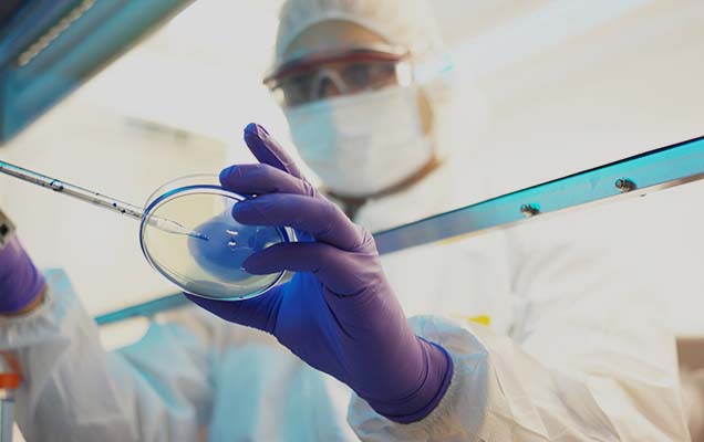 scientist in protective gloves doing experiments in a lab, using an online medical laboratory science degree