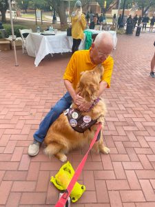 picture of usm president dr joe paul hugging therapy dog golden retriever